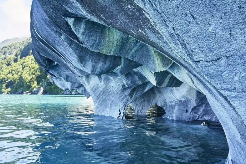 Серия пещер в плите гладкой скалы на берегу