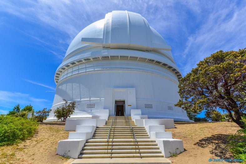 Форма белого купола Паломарской обсерватории на фоне голубого неба.