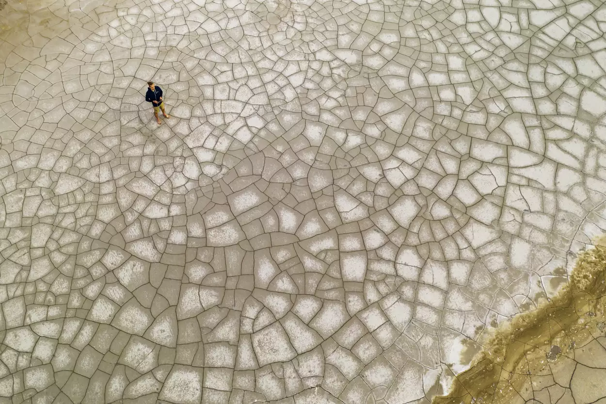 Вид с воздуха на человека на потрескавшейся земле. Концепция глобального потепления