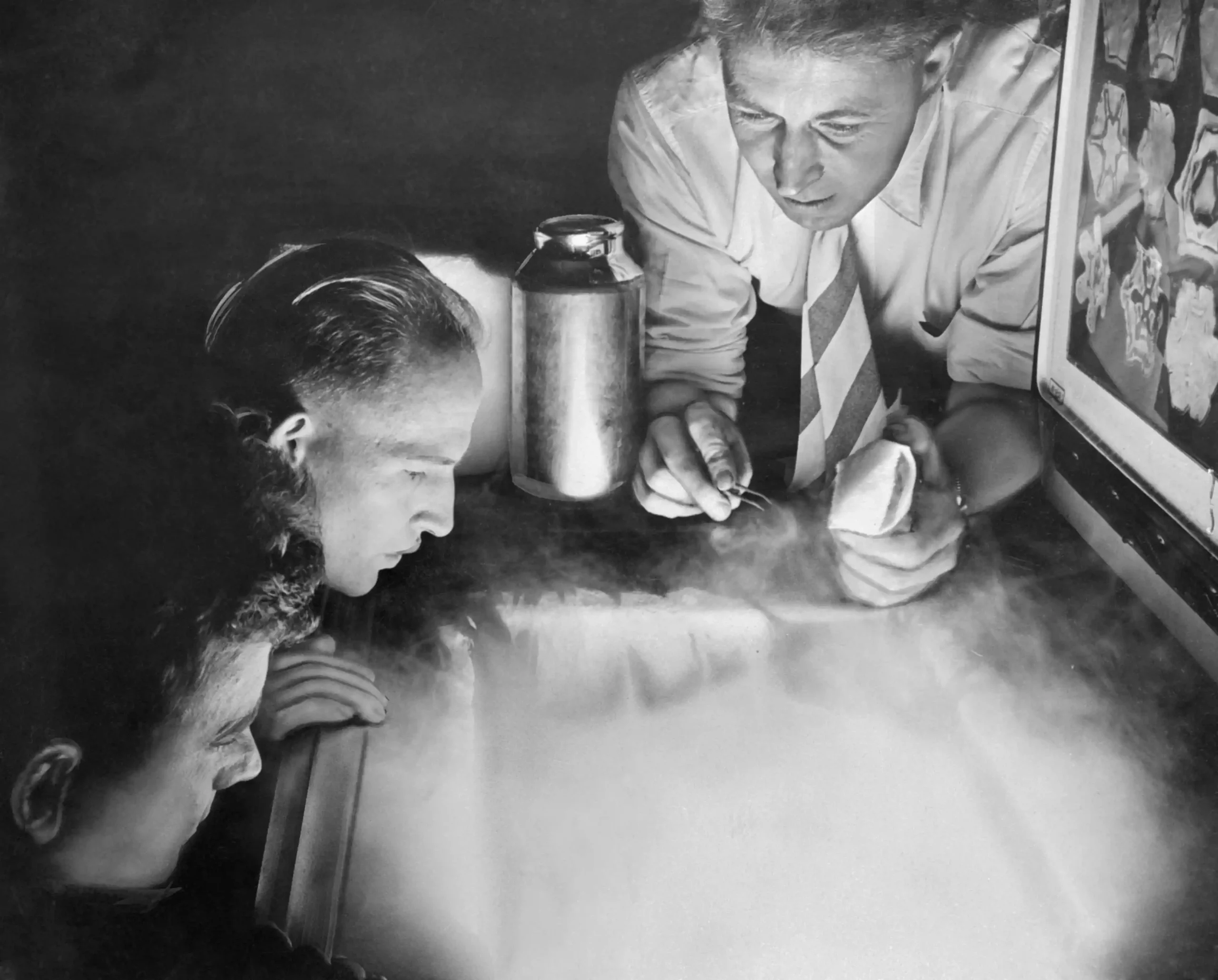 Трое ученых парят над морозильной камерой, из которой вырывается холодный воздух