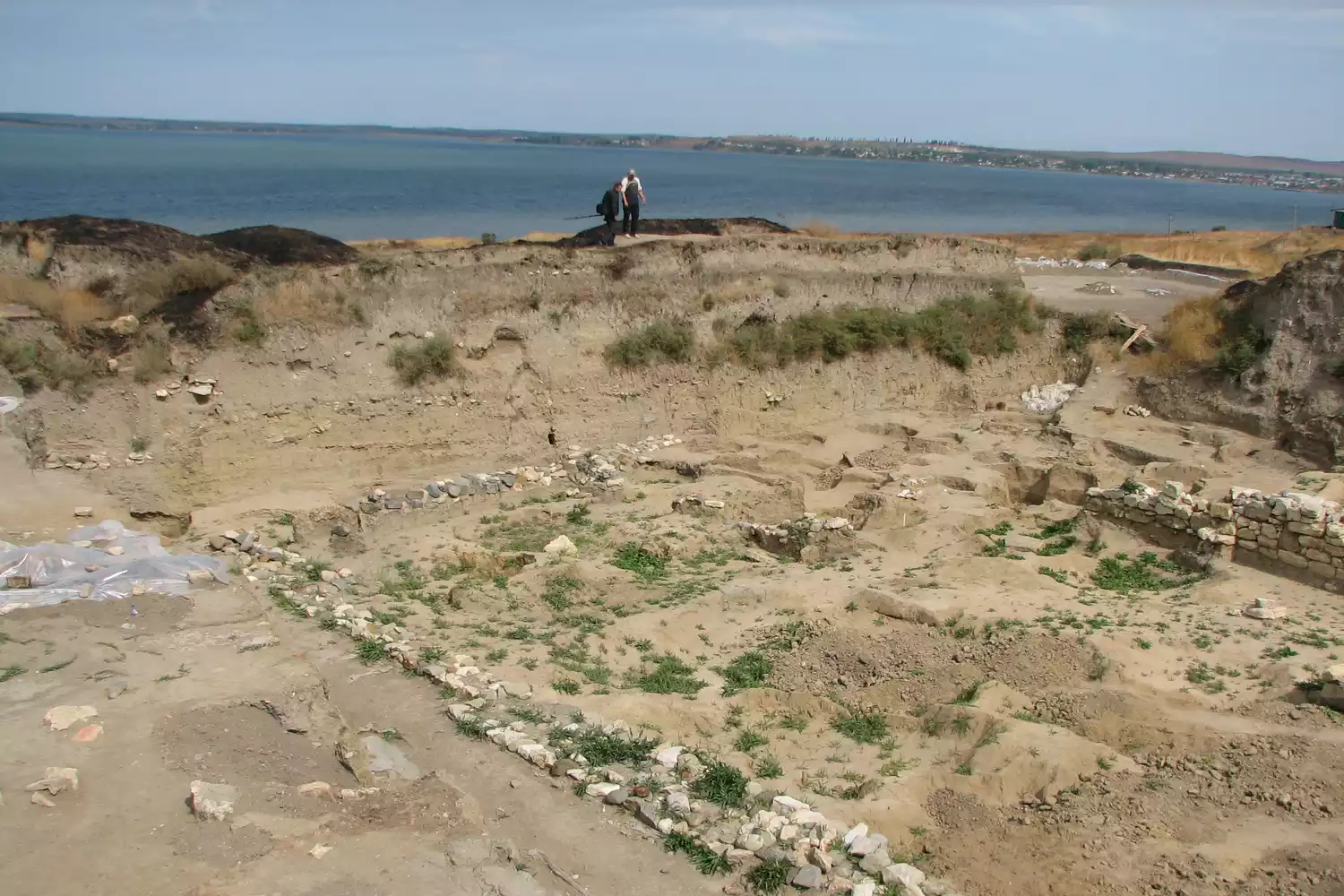 Раскопанные останки с морем на заднем плане