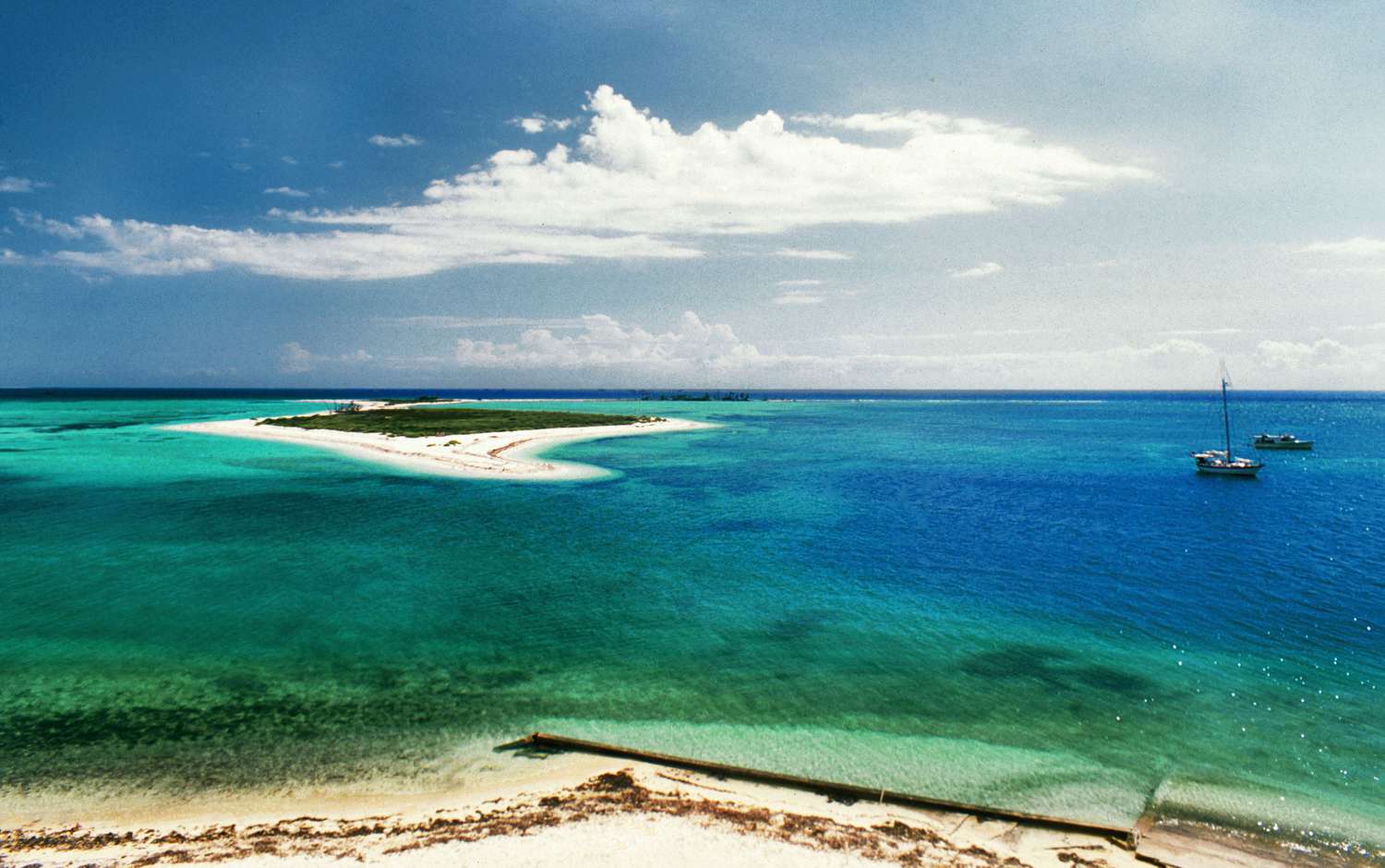 Вид с воздуха на ярко-белый песок, окруженный мелководьем
