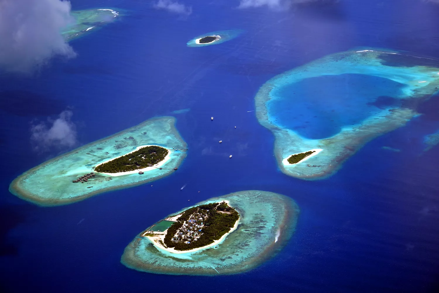 Вид с воздуха на четыре Мальдивских острова и лагуны в глубокой синей воде