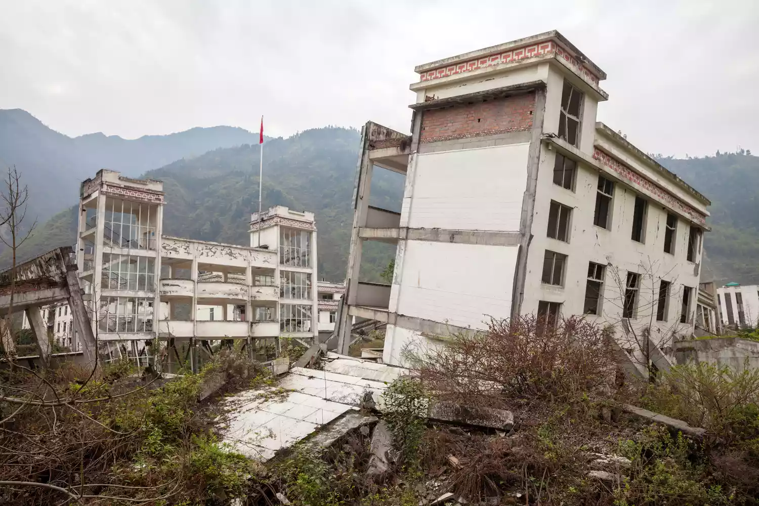 Здания, поврежденные землетрясением, на фоне гор